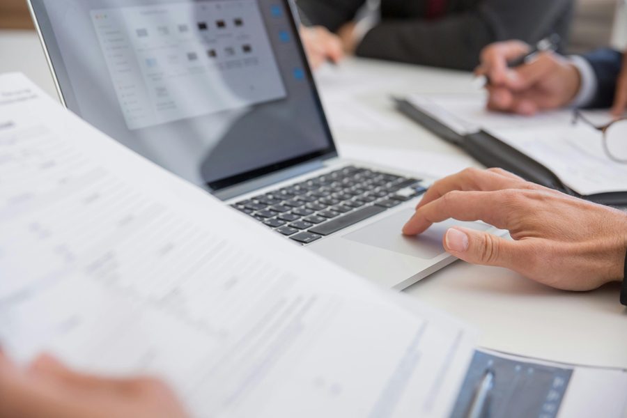 Un ordinateur et des notes évoquent les démarches administratives en ligne.